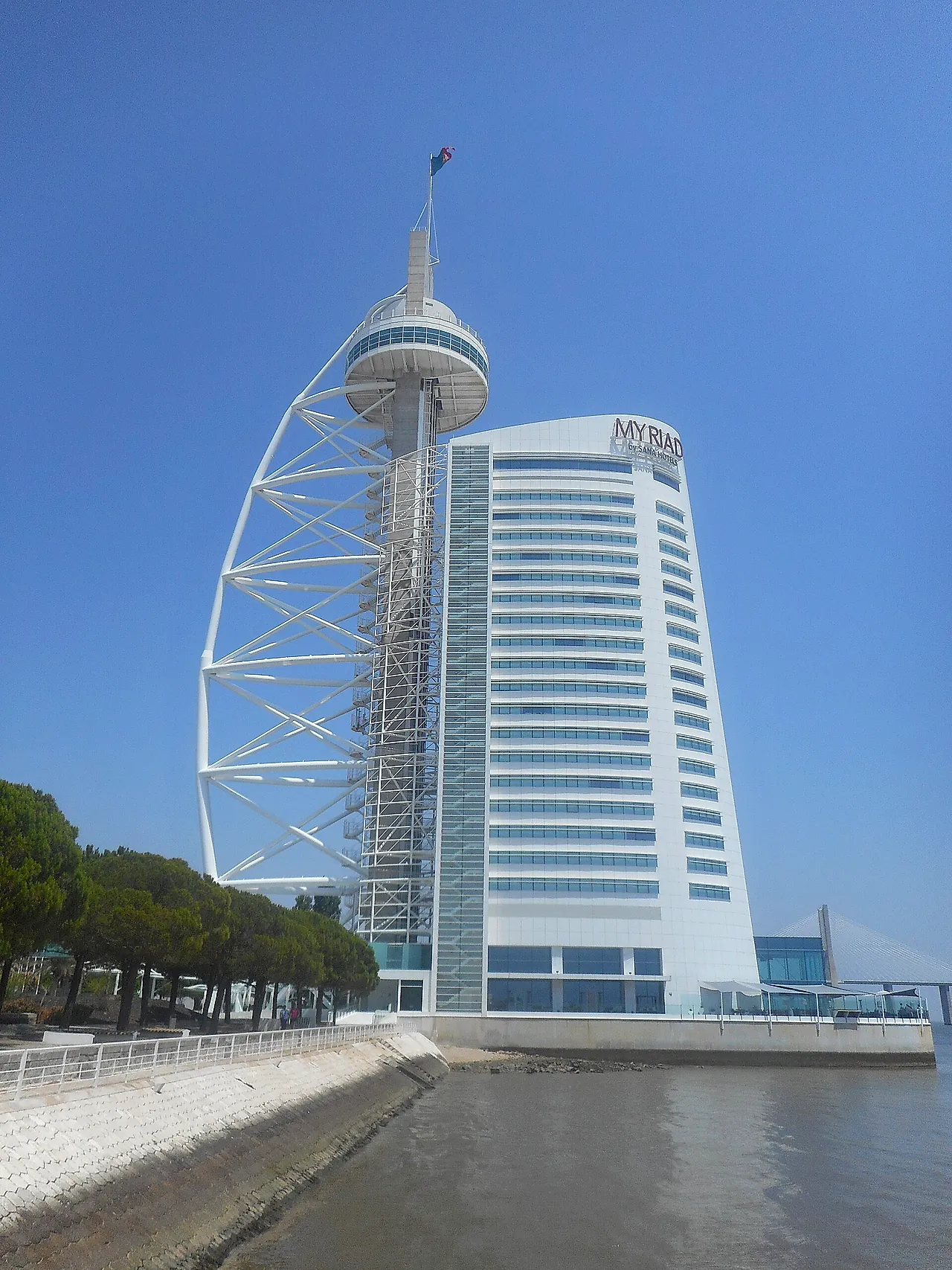 The Vasco da Gama Tower, a tall white sail-shaped tower beside a hotel block, at Parque das Nações